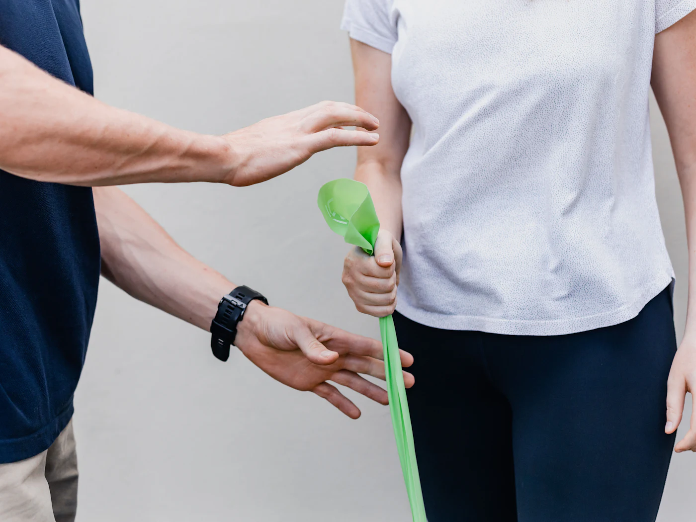 Fisioterapeuta guiando un ejercicio de mano con una pelota terapéutica