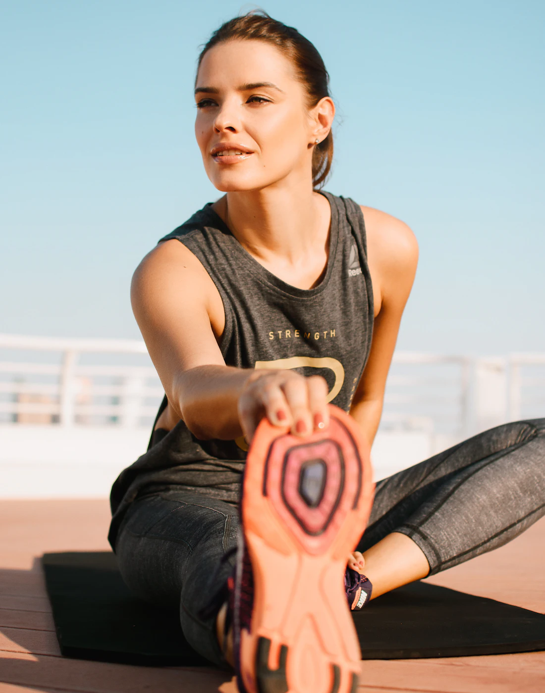 Mujer estirando la pierna antes de entrenar
